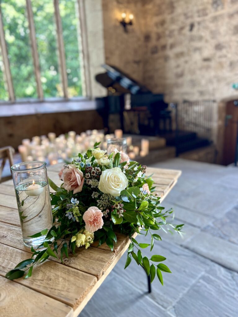 Wedding flowers on table with piano in background