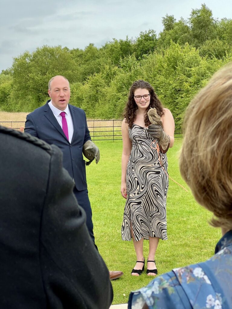 Wedding guest holds baby owl at Stretton Manor Barn