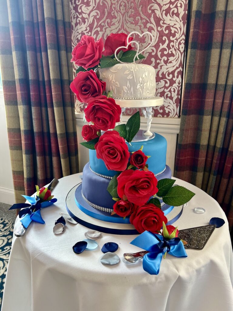 Wedding cake in blue and white with red roses