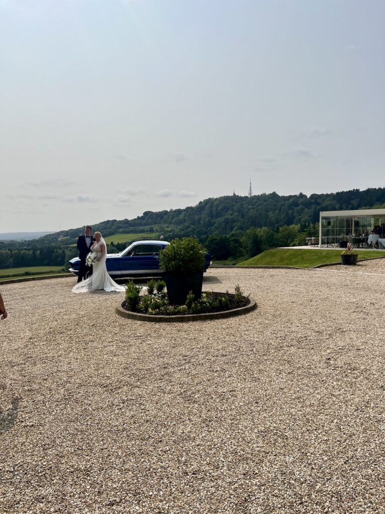 Wedding couple with blue sports car