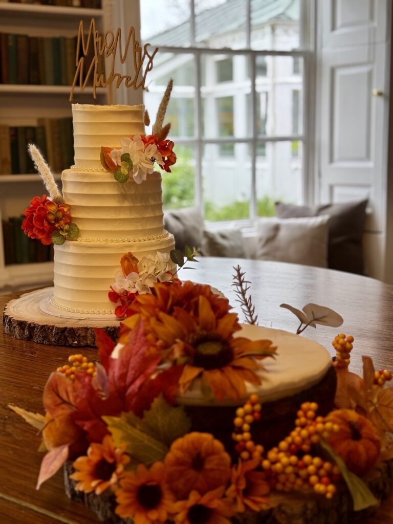 Wedding cake with autumnal flowers at Chilston Park Hotel