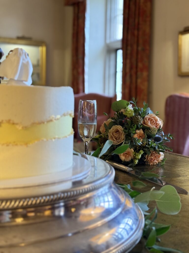 Wedding cake and bridesmaids flowers at Llangoed Hall in Wales