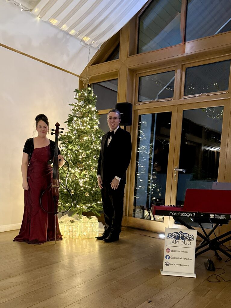 JAM Duo Jules and Anne-Marie by a Christmas Tree with A Nord Stage Piano in the foreground