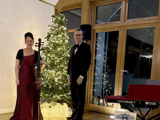 JAM Duo Cello and PIano Duo beside a Christmas Tree and Nord Stage 3 piano