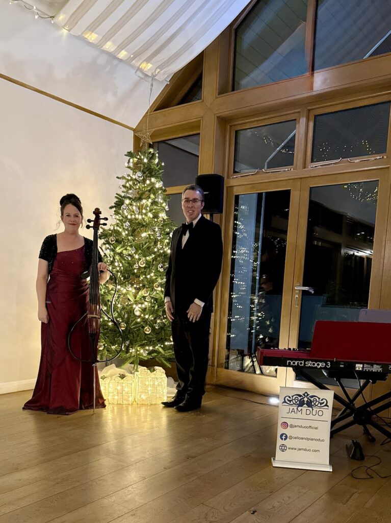 JAM Duo Cello and PIano Duo beside a Christmas Tree and Nord Stage 3 piano